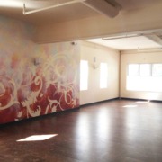 Large orange and gold botanical yoga studio mural in the Rajas Room